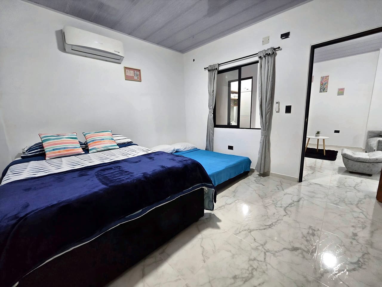 Habitación con cama doble, cama nido doble y aire acondicionado